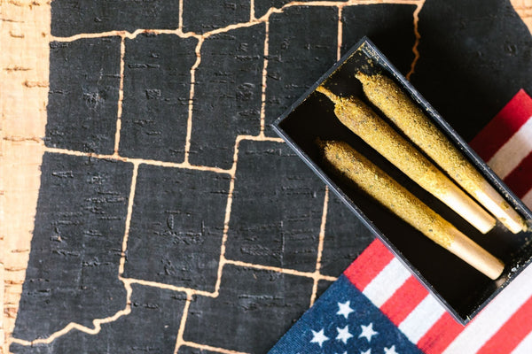Three prerolls in a black box sitting on a table with a map of US states and a US flag.